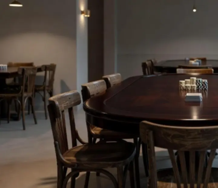 Večerně nasvícený pokerový stůl připravený v restauraci Kout Chuti